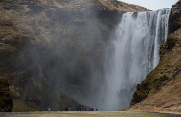 Tourists enjoying the Skogafoss waterfall and river in Iceland