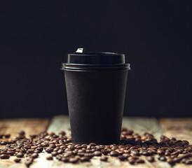 take away coffee cup and coffee beans on wooden background