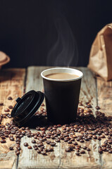 take away coffee cup and coffee beans on wooden background