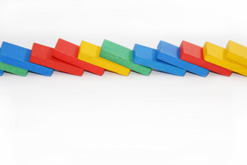 Wooden colorful toys lie nearby. Dominoes chain reaction