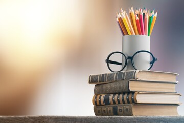 Stack of vintage books, eyeglasses and pencils, education and learning