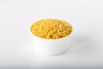 Bowl of uncooked vermicelli pasta isolated on white background. 