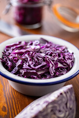 Obraz na płótnie Canvas Sliced fresh red cabbage in bowl on wooden table.