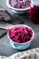 Obraz na płótnie Canvas Red sauerkraut. Sour pickled cabbage in blue pot.
