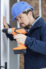 male builder using cordless drill