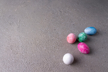 Multi-colored eggs on beige plaster. Horizontal orientation.