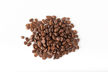 Pile of coffee beans on a white surface. Background and texture. 