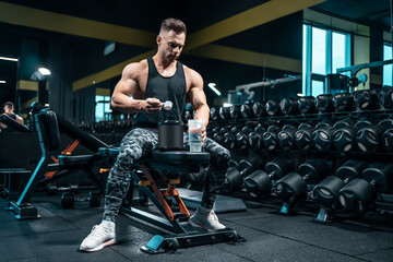 Fototapeta na wymiar athlete man preparing protein cocktail or use sport nutrition supplement in gym