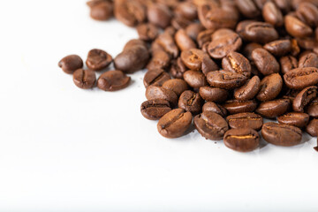 Pile of coffee beans on a white surface. Background and texture. 