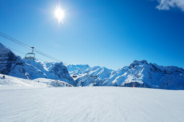 Alps mountain peaks and clean empty ski trails in Pralognan-la-Vanoise range over snowy tops