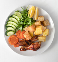 plate of healthy food Baked chicken wings. baked vegetables for salad.