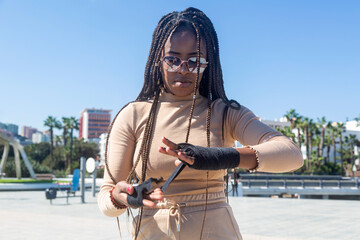 Portrait of beautiful young afro american woman putting bandages on her hands to practice martial arts, boxing.