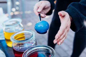 Blaues Osterei mit dem Löffel vorsichtig färben