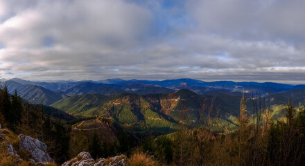 soft green mountains in the sun and grey sky panorama