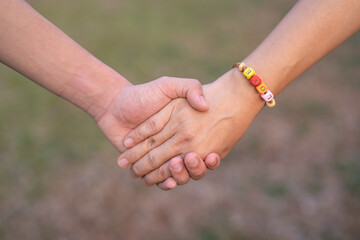Couple holding hands with hand string of LOVE word in blur background, Happy Women's, Mother's, Valentine's Day concept.