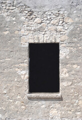 old stone building remains with clean black open window