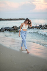 Young slim beautiful woman on sunset beach