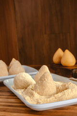Brazilian uncooked breading croquettes (coxinhas de frango) on a wooden kitchen table
