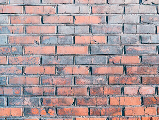 Obraz premium The wall, made of old red bricks, darkened by old age. Ancient vintage brick wall background. Brick wall backdrop
