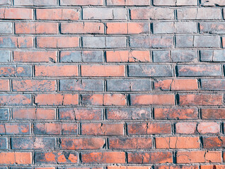 The wall, made of old red bricks, darkened by old age. Ancient vintage brick wall background. Brick wall backdrop