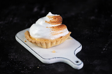 Homemade lemon meringue pie baked on black background