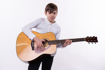 Obraz premium Photo of a young teenager playing a guitar and lookimg at the camera