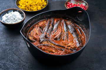Modern style slow cooked Persian lamb eggplant stew khoresh bademjan served with rice and yoghurt as close-up in a design pot