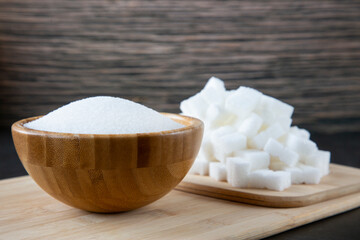 Bowl wood and  white sand sugar and lump sugar on wooden background