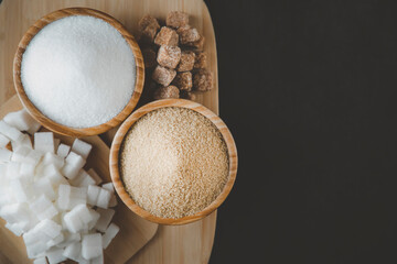Bowl wood and and white and Brown sand sugar and lump sugar on dark background
