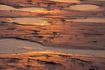 frozen puddle during sunset on the beach in St. Peter Ording