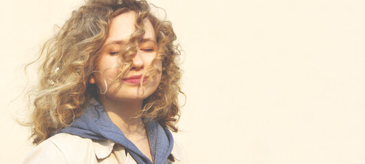 Happy young teenage girl with curly hair smiling and looking to the side. People, travel, teens, emotions concept. Smiling girl, close up portrait.