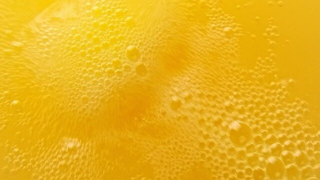 Yellow bubbling liquid boiling texture. Carbonated drink background.