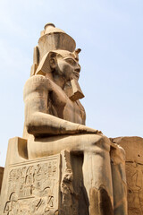 Huge statue of sitting Ramses III pharaoh in Karnak temple - obrazy, fototapety, plakaty