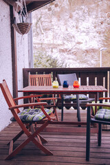 Wooden furniture on the balcony. Wooden table and chairs on the terrace in winter. Balcony in winter. 