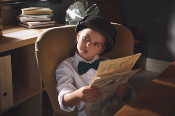 Cute little detective with newspaper in office