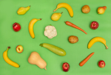 Flat lay composition with fresh organic fruits and vegetables for first baby food on green background. Top view. Healthy child nutrition, baby feeding. Copy space. Diet and vegetarianism. 