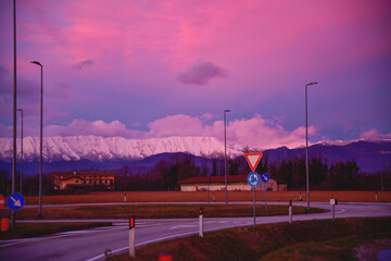 beautiful red-pink sunset and road in the fields