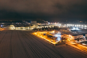Aerial view of the trucks unloading at the logistic center. Night view with a bit of snow.
