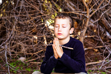 A 7-year-old boy reflects and meditates relaxed in nature.