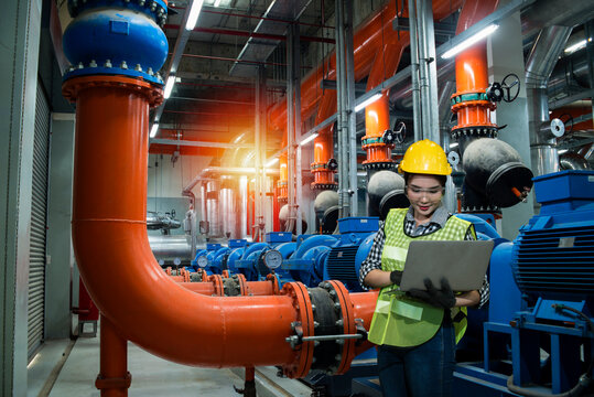 Women Worker Using  Laptop On Chiller Water Cool In Plant Room Background.