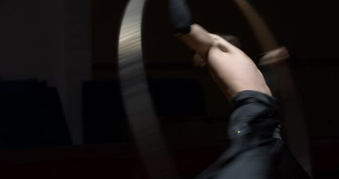 Wheel gymnastics training of a circus performer, dark room, stage, 4k