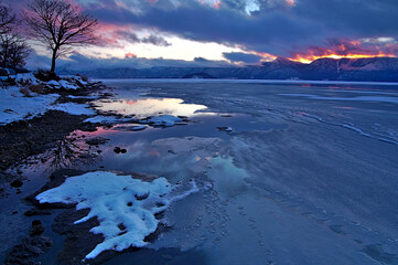 氷に覆われた冬の山間の湖。日本の北海道の屈斜路湖。