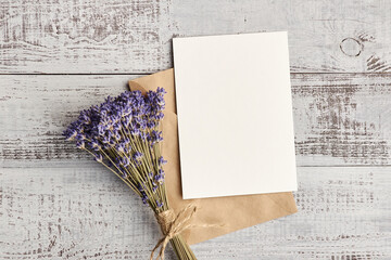Invitation card with copy space and lavender flowers bunch on wooden background