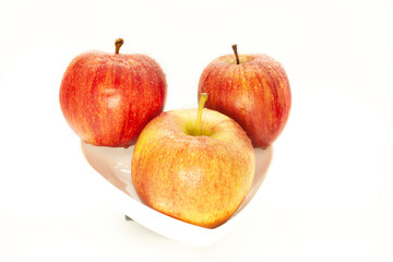 Three apples arranged on a white bowl juicy sweet and fresh ready to eat