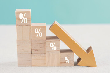 Wooden blocks with percentage sign and down arrow, financial recession crisis, interest rate fall, investment reduce, risk management concept - obrazy, fototapety, plakaty