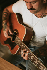 Obraz premium Tattooed singer songwriter playing an acoustic guitar