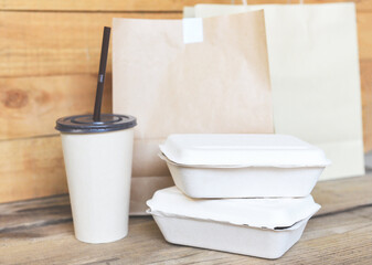 Disposable eco friendly packaging containers with paper cup and craft paper food on wooden table at home, Service food order online delivery food box take away boxes.