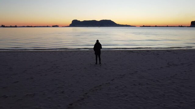 Sunset on the beach, where we can see at the bottom the city of gibraltar at the very first hour of the day, this video was taken from Algeciras bay.