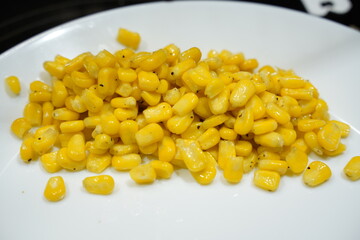 Yellow Corn Niblets on a White Plate Background