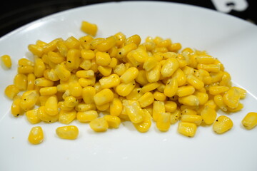 Yellow Corn Niblets on a White Plate Background